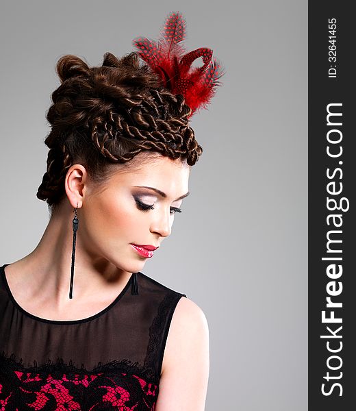 Woman With Fashion Hairstyle With Red Feather In Hairs