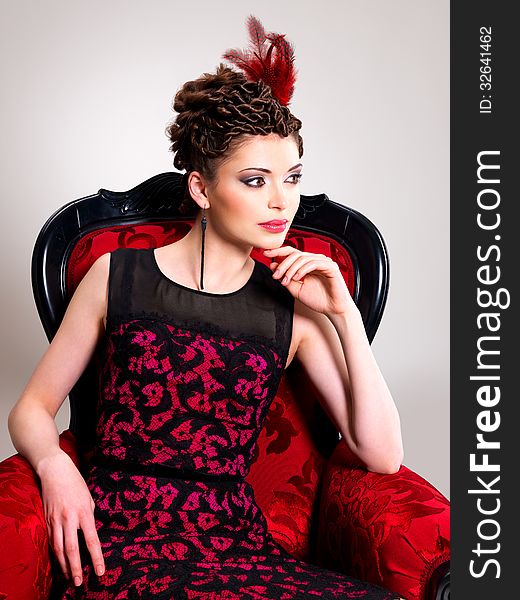 Woman with fashion hairstyle and red armchair