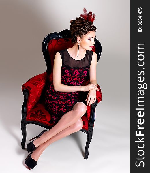 Woman With Fashion Hairstyle And Red Armchair