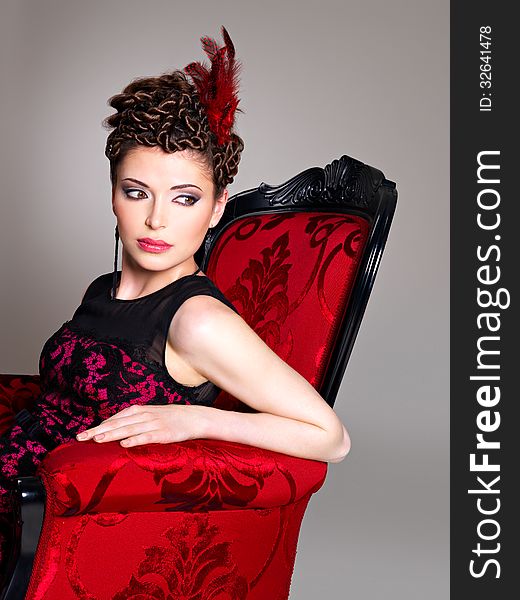 Woman With Fashion Hairstyle And Red Armchair