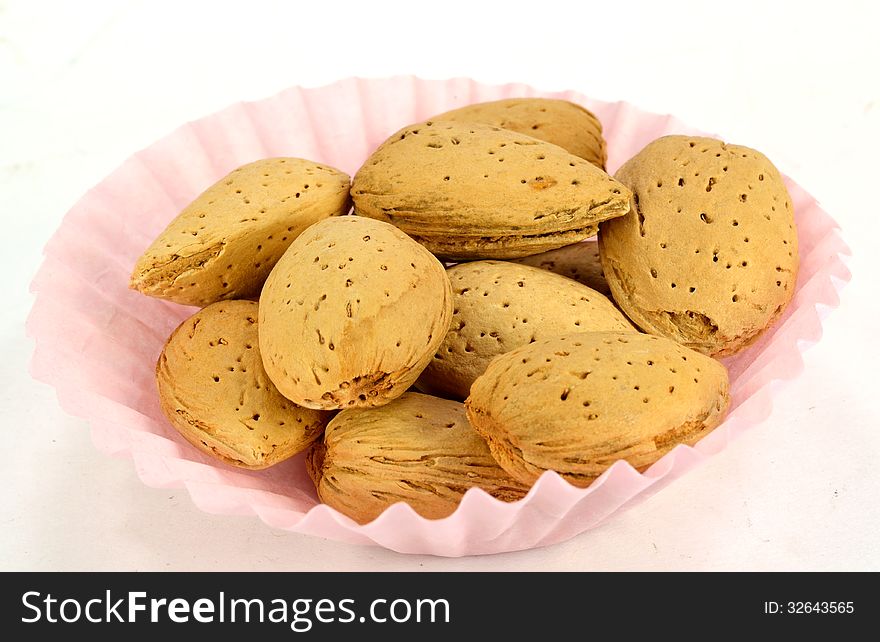 A small paper cup of almonds in the shell.