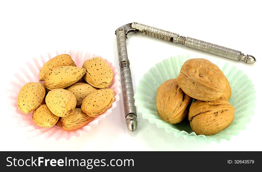 Walnut and almonds in paper cups with a nutcracker. Walnut and almonds in paper cups with a nutcracker.