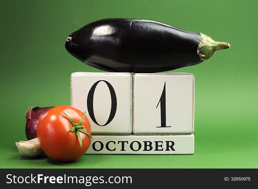 Save the date white block calendar for October 1, World Vegetarian Day with eggplant, tomato and onion on green background.