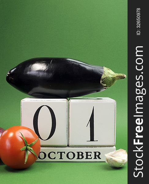 Save the date white block calendar for October 1, World Vegetarian Day with eggplant, tomato and onion on green background. Vertical with copy space. Save the date white block calendar for October 1, World Vegetarian Day with eggplant, tomato and onion on green background. Vertical with copy space.