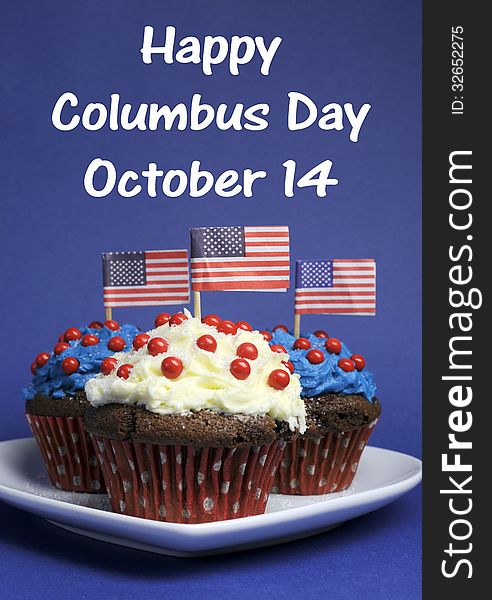 Happy Columbus Day for October 14 message and Red, White and Blue chocolate cupcakes with USA Stars & Stripes flags on blue background.