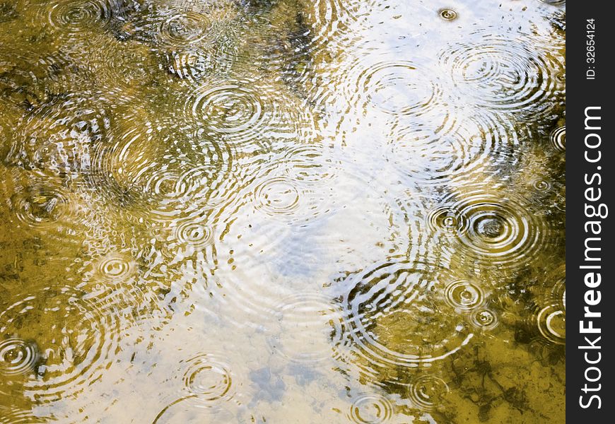 Big puddle surface with scenic circles of falling raindrops. Big puddle surface with scenic circles of falling raindrops