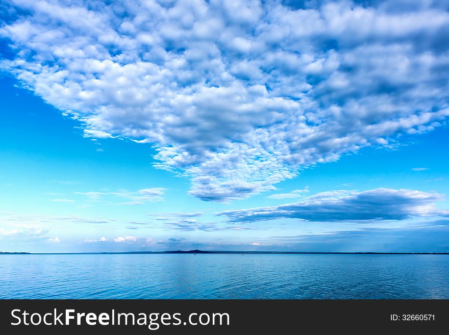 White cumulus clouds over the lake