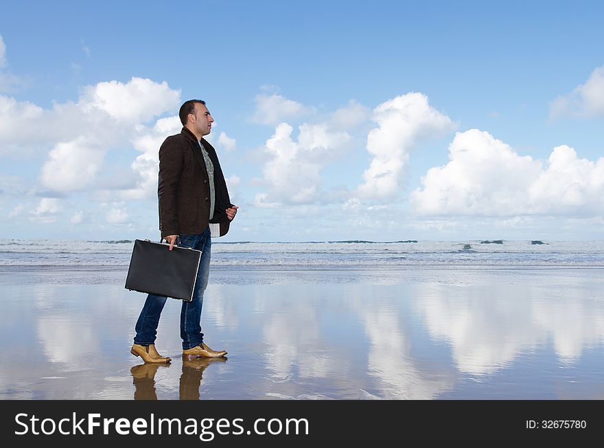 Man with briafcase walking on the beach. Man with briafcase walking on the beach.