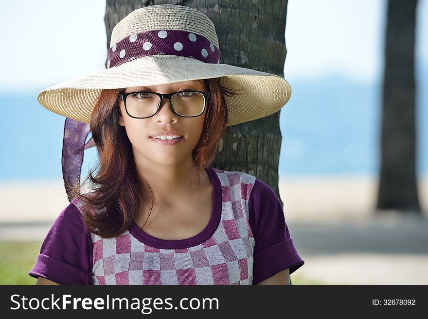 Portrait of a cute Asian girl in a hat on a background of the sea