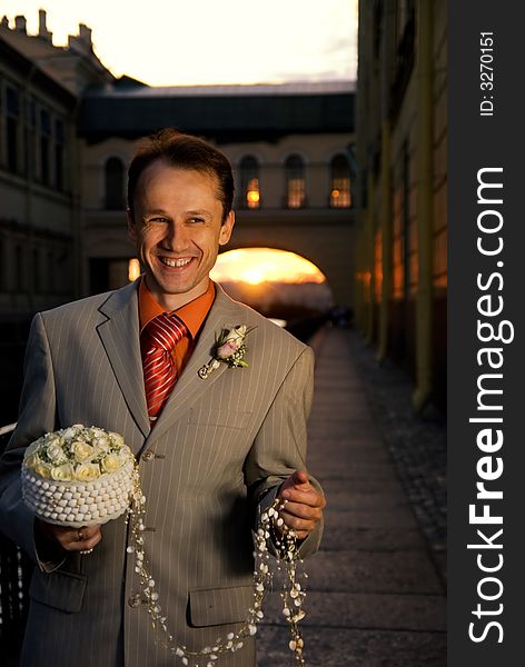Groom with a bouquet of white roses