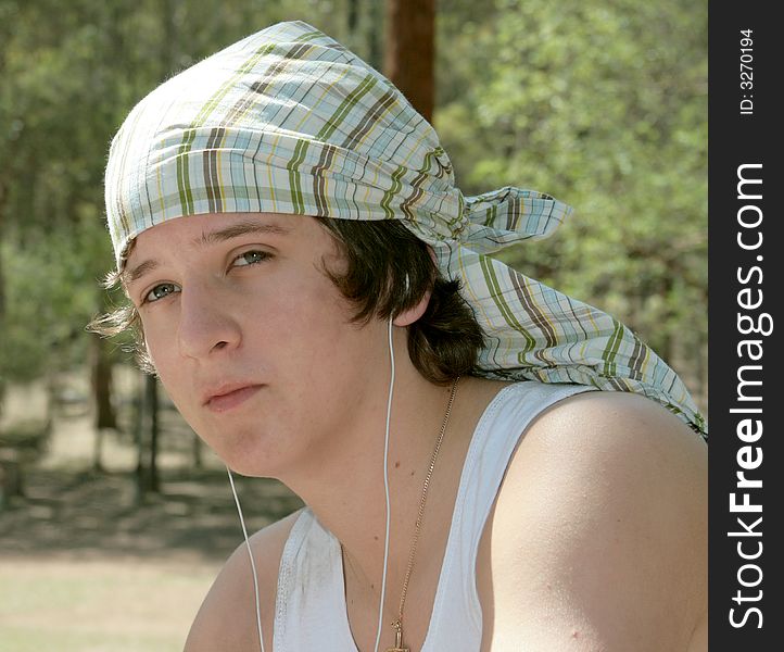 Teenage boy listening to music on MP3 player outdoors. Teenage boy listening to music on MP3 player outdoors.