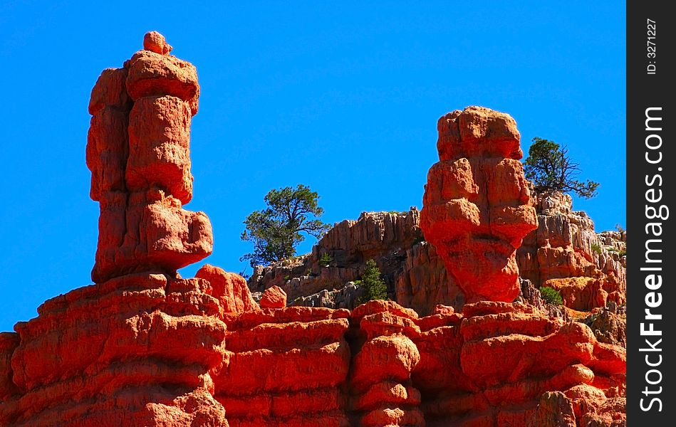 Two wind sculpted red sandstone hoodoos projected against a deep blue sky. Two wind sculpted red sandstone hoodoos projected against a deep blue sky.