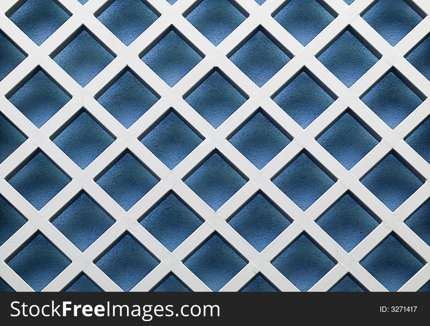 Image of a metal lattice over a blue wall. Image of a metal lattice over a blue wall