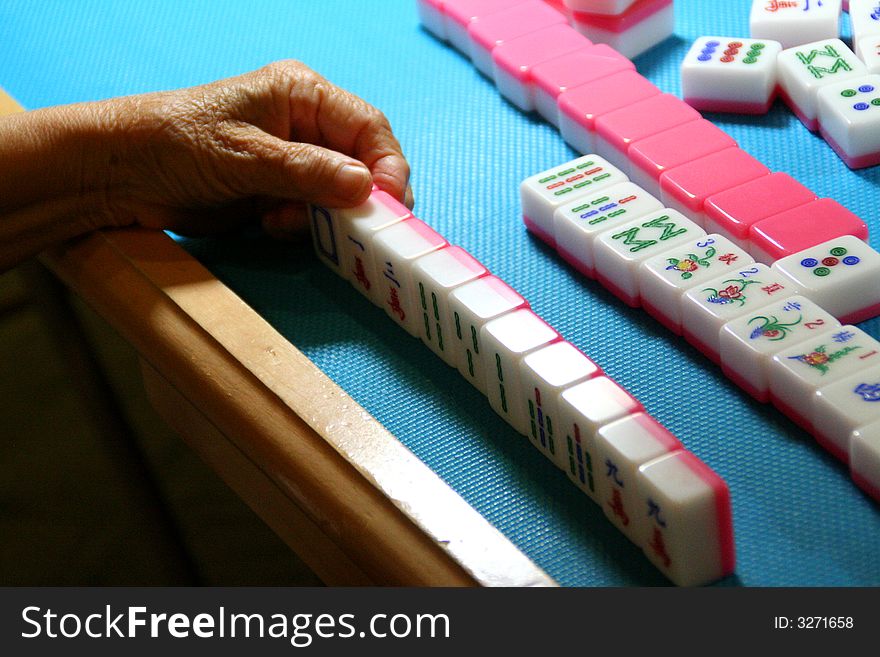 A mahjong player is highly involved in the game