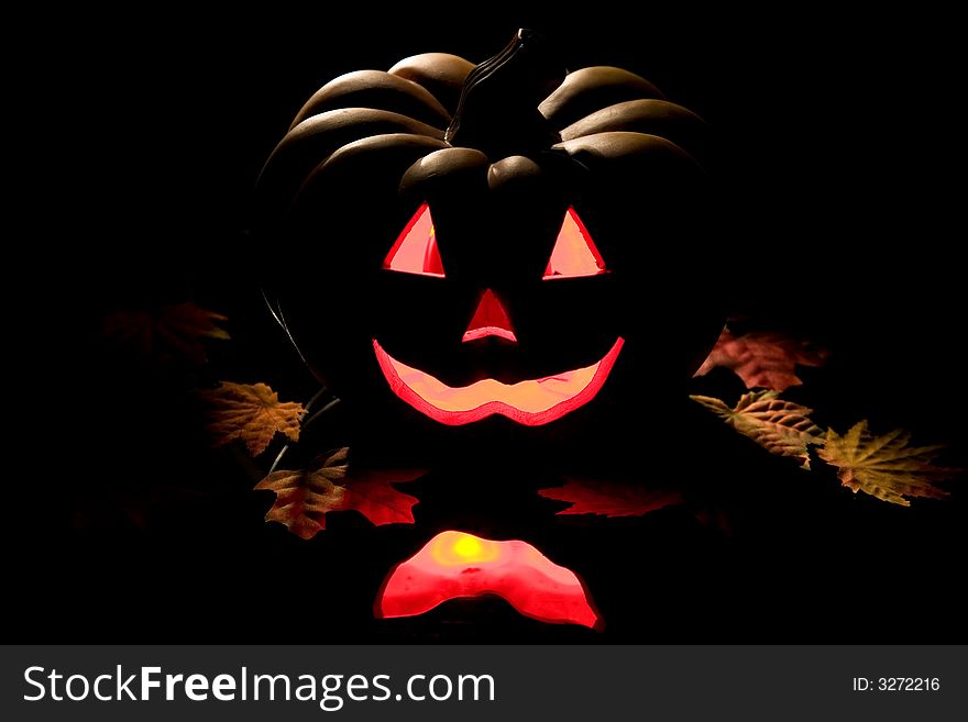 Halloween pumpkin with leaves on a black background. Halloween pumpkin with leaves on a black background.