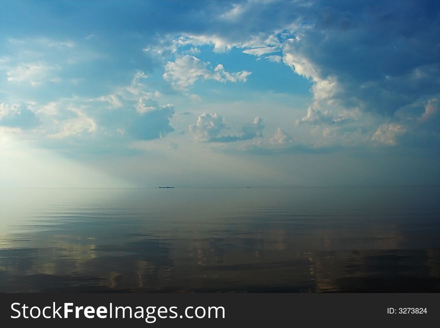 Sun and clouds are reflecting in still water. Sun and clouds are reflecting in still water