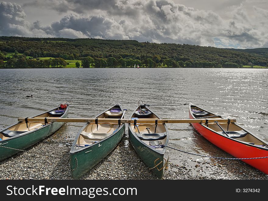 Canoes on the shore of Coniston Water in the English lake District. Canoes on the shore of Coniston Water in the English lake District