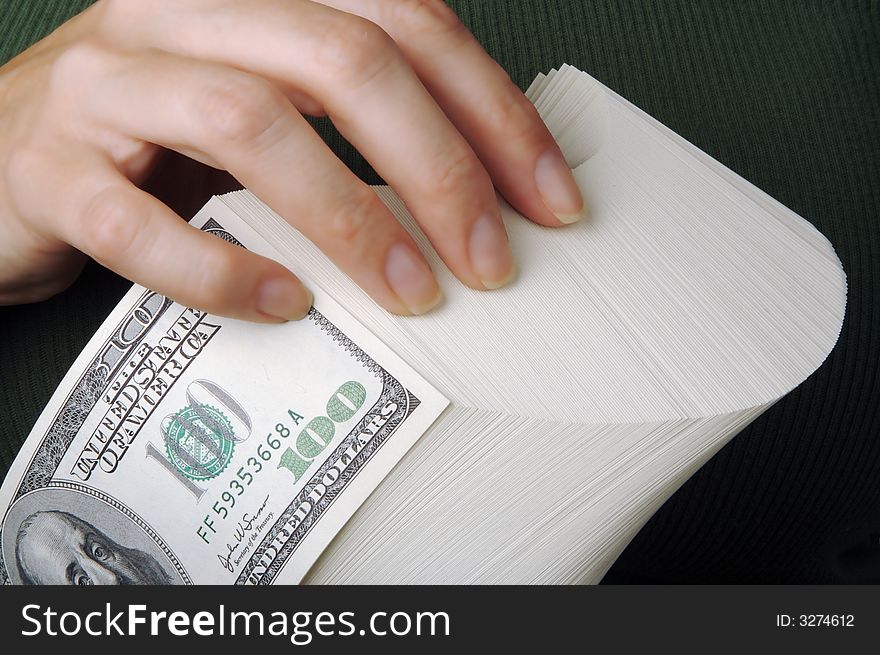 Woman holds a stack on one hundred dollar bills. Woman holds a stack on one hundred dollar bills.