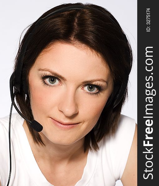 Beautiful girl with dark hair with headphones and microphone wearing white blouse