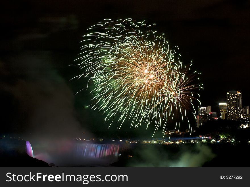 Firework went off on the niagara fall waterfall which lit by effect lights. Firework went off on the niagara fall waterfall which lit by effect lights