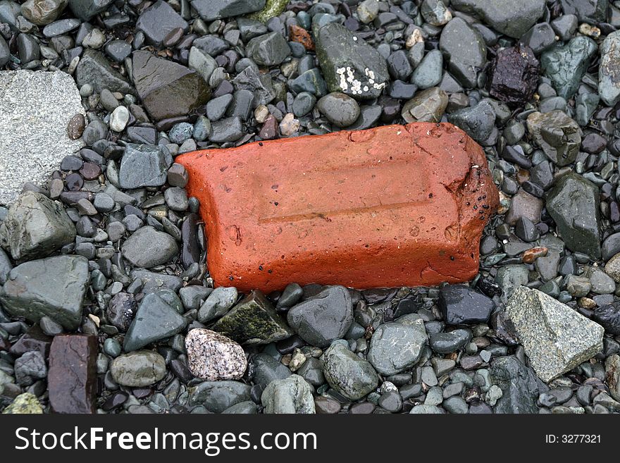 An old brick being worn smooth by the ocean.