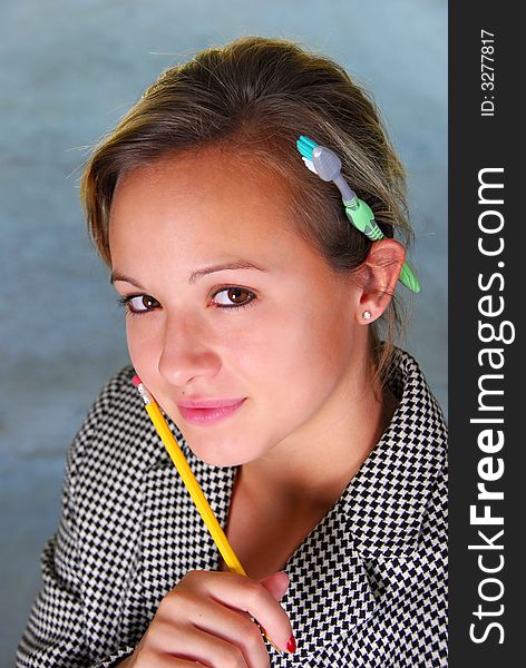 A pretty girl holding a pencil with a toothbrush over her ear. A pretty girl holding a pencil with a toothbrush over her ear.