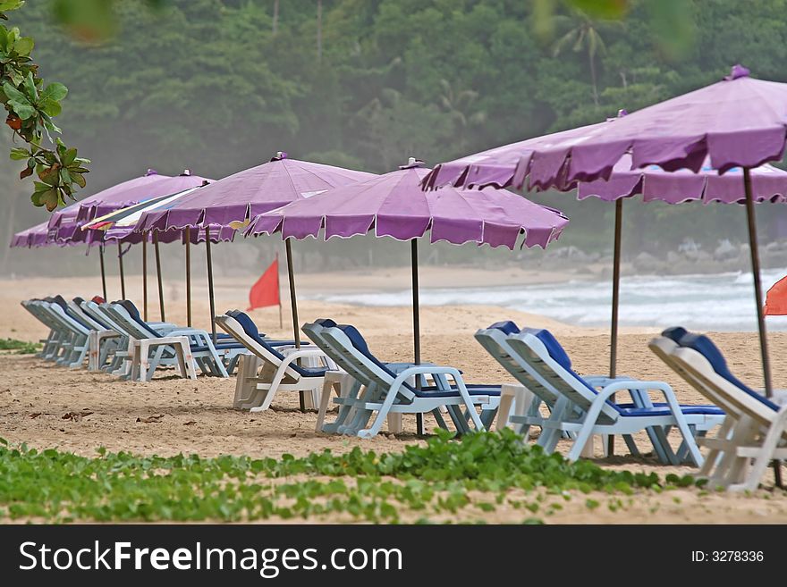 Deserted sunloungers on a tropical beach in Thailand. Deserted sunloungers on a tropical beach in Thailand