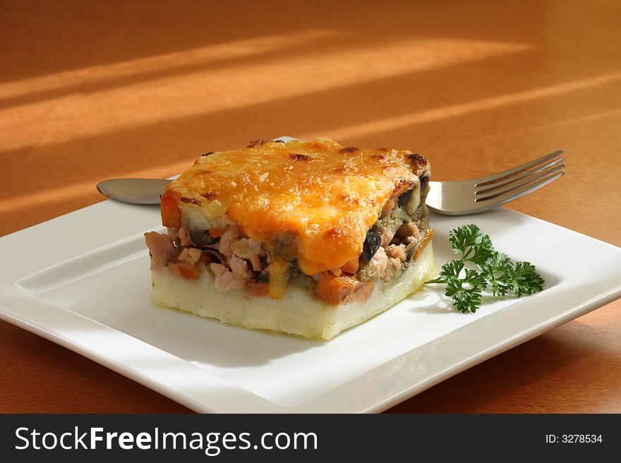 A meal of chicken and potato pie on white platter