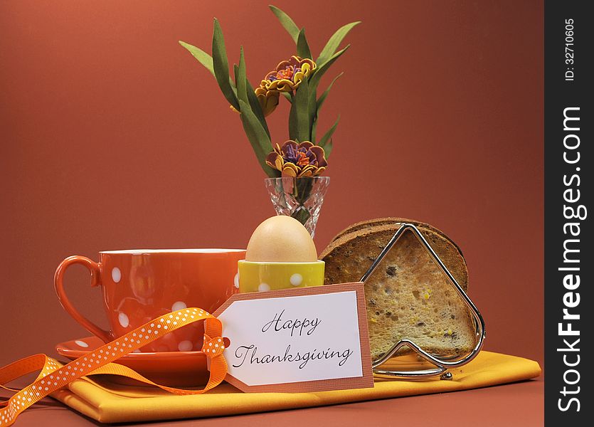 Happy Thanksgiving breakfast for your special one with toast and egg with coffee or tea in an orange polka dot cup and saucer, with heartfelt gift tag, and flowers in vase