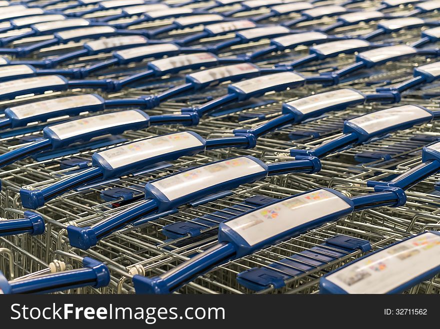 Metal shopping trolley stack with blue plastic hand grip