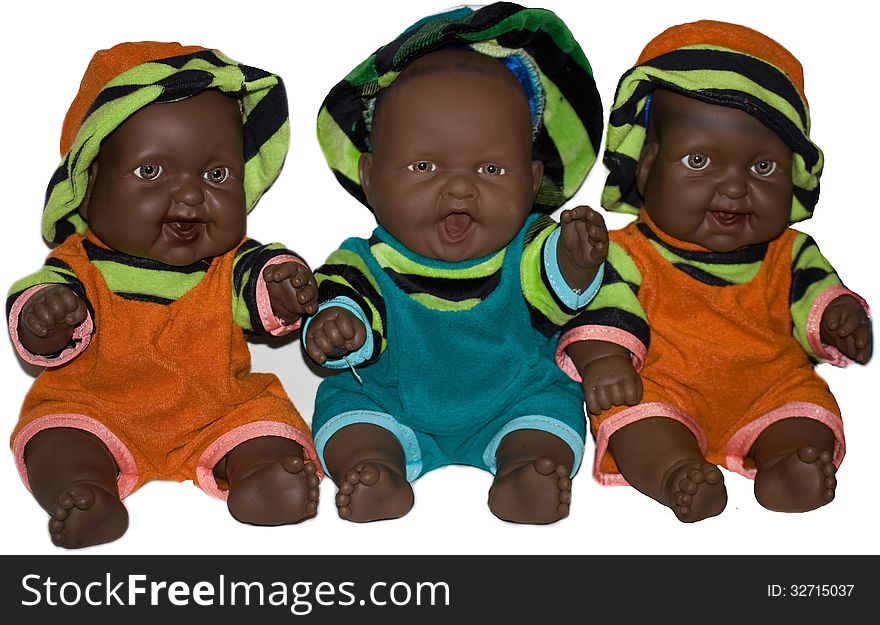 Three dark-skinned colorfully dressed smiling baby dolls. Three dark-skinned colorfully dressed smiling baby dolls.