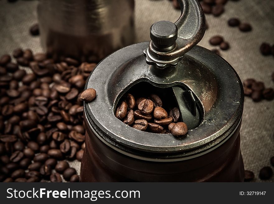 Coffee mill with coffee beans on flax