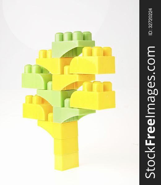 Green and yellow block toy in tree figure on white background. Green and yellow block toy in tree figure on white background