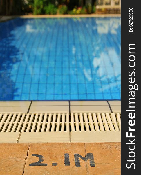 Close up of the edge of swimming pool and sign indicating the depth of the pool. Close up of the edge of swimming pool and sign indicating the depth of the pool