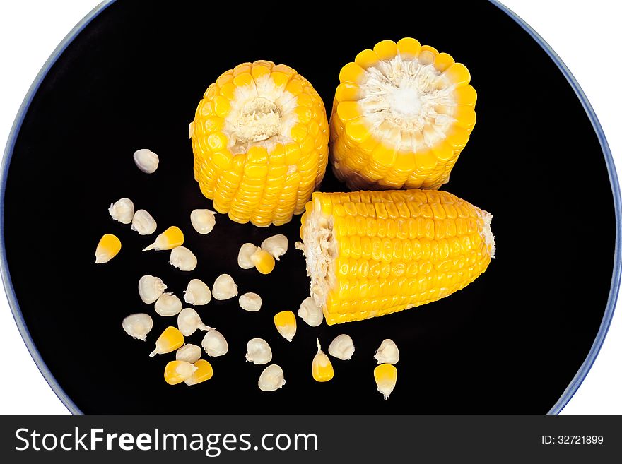 The divided boiled corn on black plate