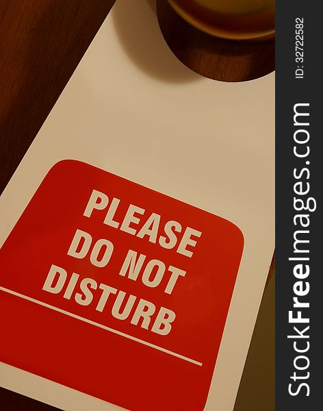 Signboard hanging on a door written: please do not disturb. Signboard hanging on a door written: please do not disturb