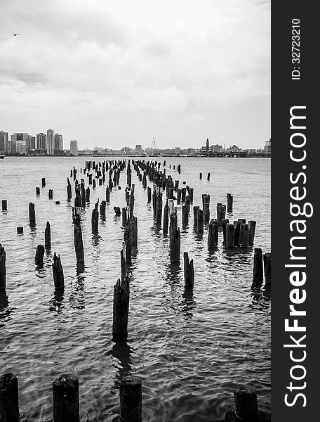 A Black & White image of broken piers the Hudson River Overlooking New Jersey City. A Black & White image of broken piers the Hudson River Overlooking New Jersey City