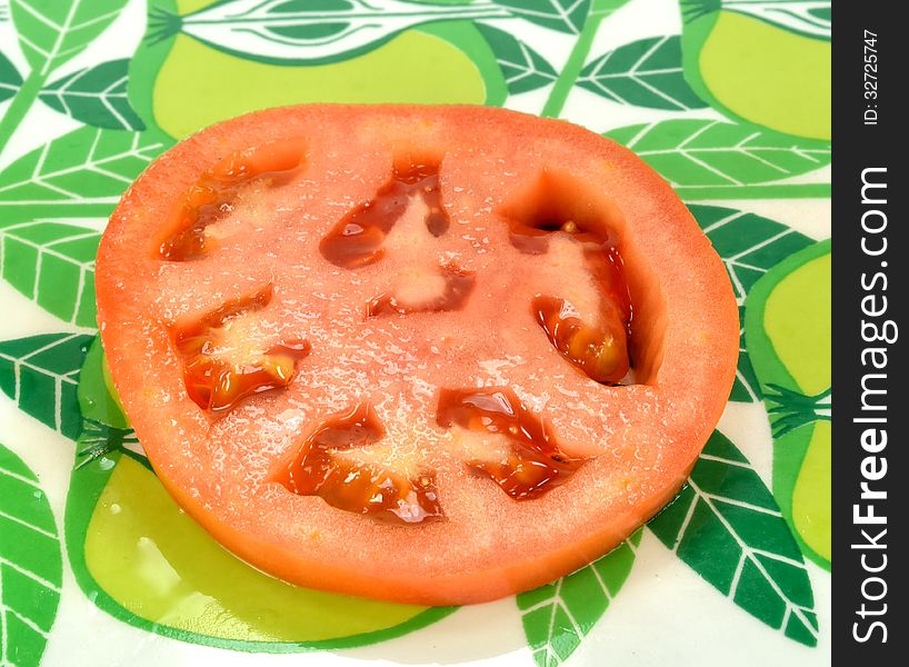 Sliced tomato on a colorful green background. Sliced tomato on a colorful green background.