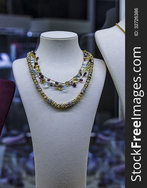 Golden necklace on jewellery showcase in window