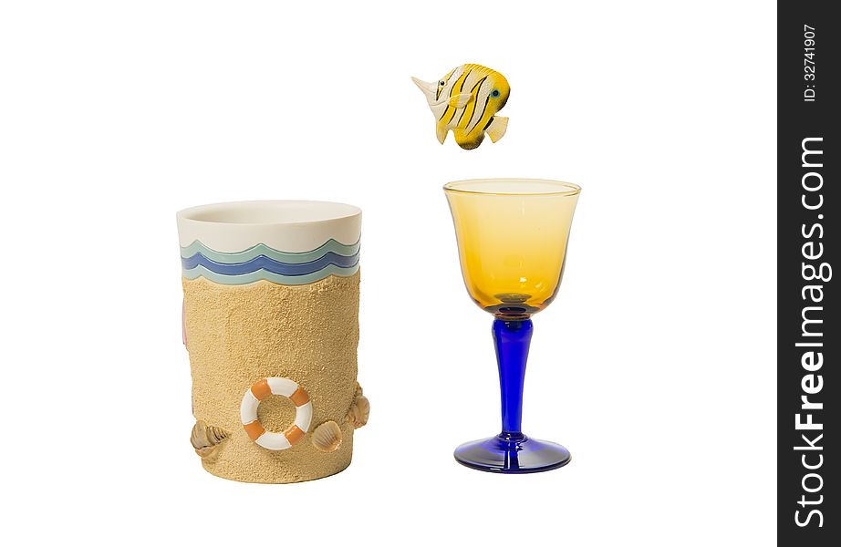 Yellow fish jump out of wine glass into beach cup isolated on white background. Yellow fish jump out of wine glass into beach cup isolated on white background