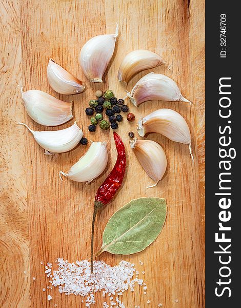 Various spices in form of flower on old chopping board