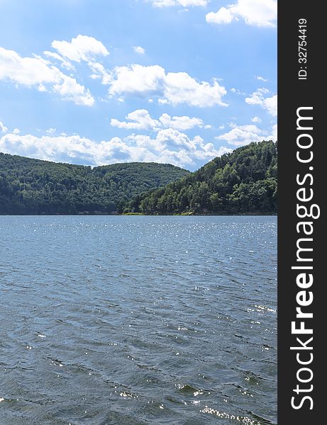 Sunny day on the lake in Poland. The artificial lake is located in the low mountains amidst the beautiful and wild forests. Sunny day on the lake in Poland. The artificial lake is located in the low mountains amidst the beautiful and wild forests