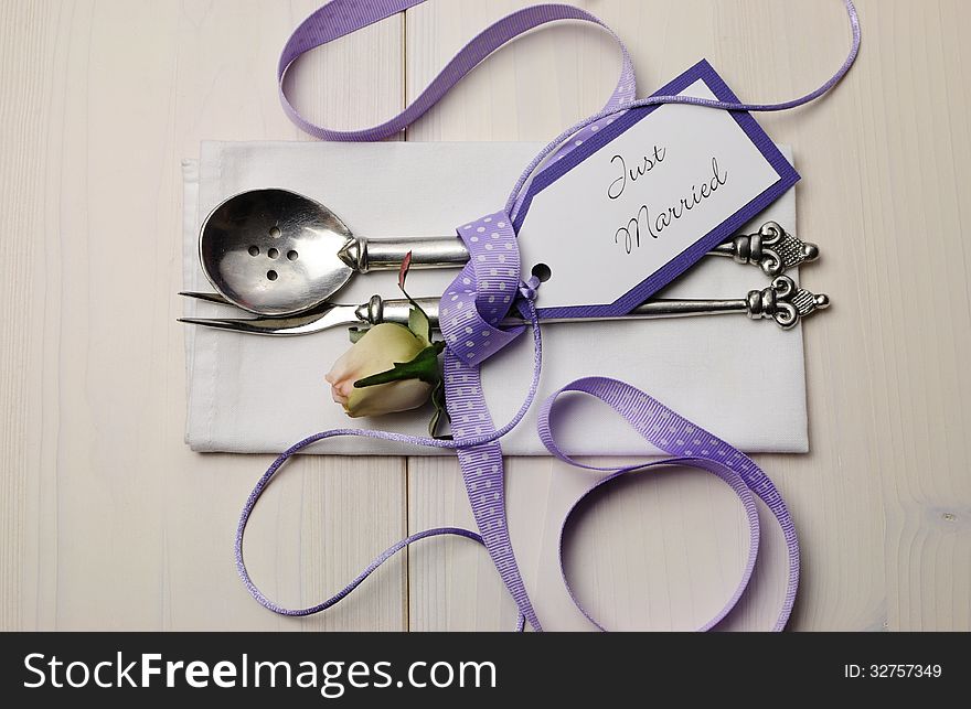 Pretty purple polka dot wedding table place setting on white shabby chic table with Just Married tag. Pretty purple polka dot wedding table place setting on white shabby chic table with Just Married tag.