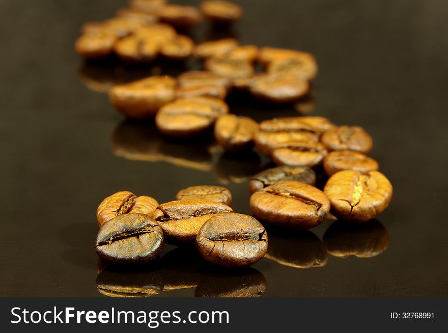 The photograph shows coffee beans placed on a black background. The photograph shows coffee beans placed on a black background.