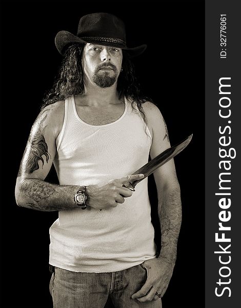 Tough sexy man with long hair wearing a cowboy hat holding a lar
