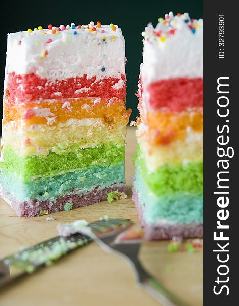 Two pieces of rainbow layer cake. Two pieces of rainbow layer cake