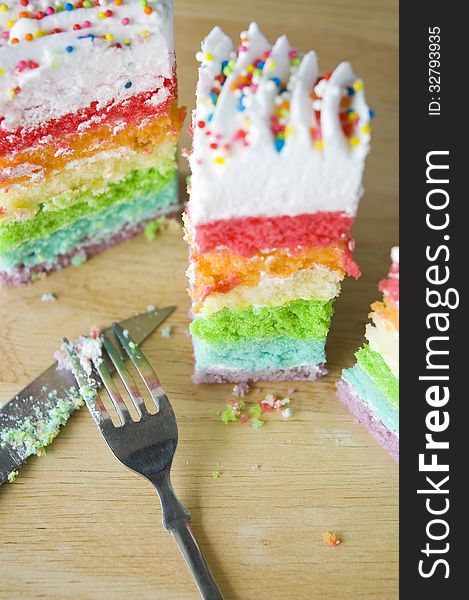 Pieces of rainbow cake with fork and knife. Pieces of rainbow cake with fork and knife