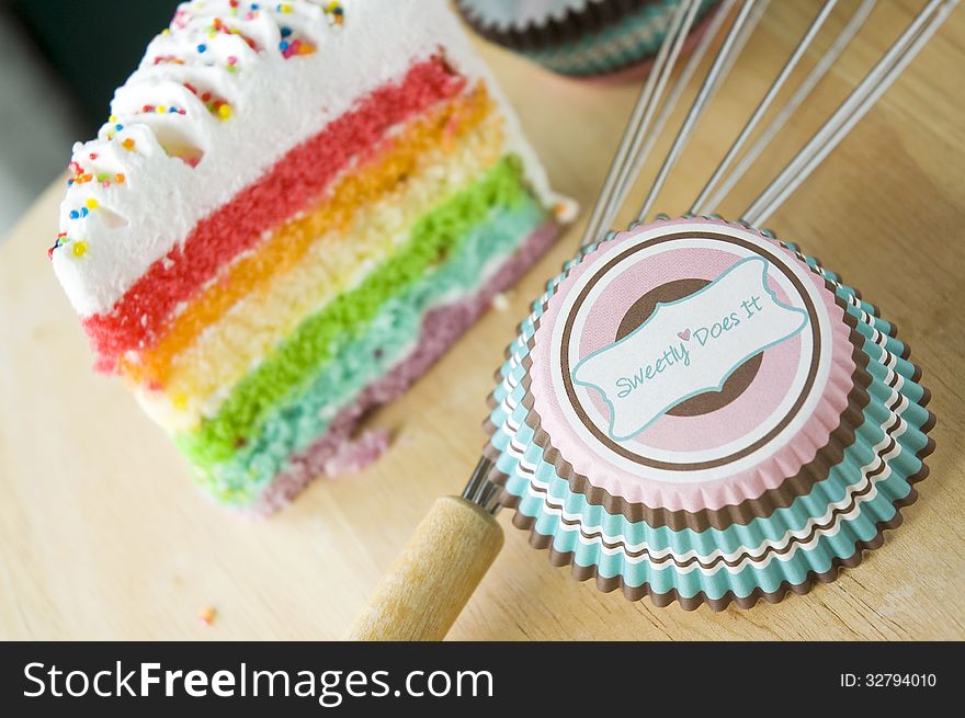 Sweet cup for cupcake with rainbow cake background. Sweet cup for cupcake with rainbow cake background
