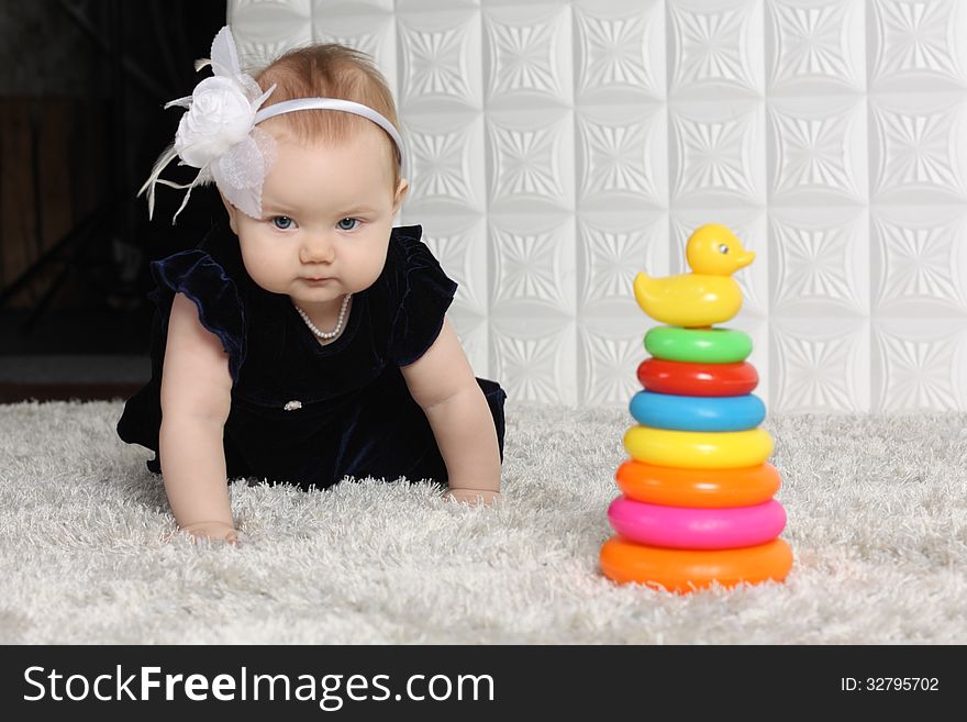 Little cute baby creeps on soft carpet