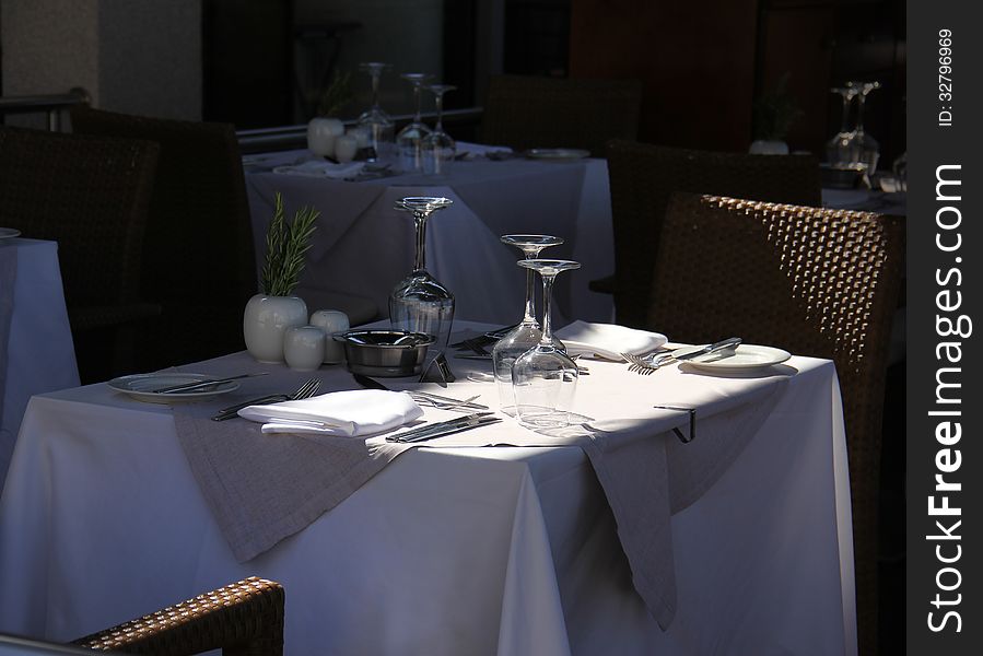 Stylish terrace restaurant table with glasses and cutlery waiting for guests. Stylish terrace restaurant table with glasses and cutlery waiting for guests